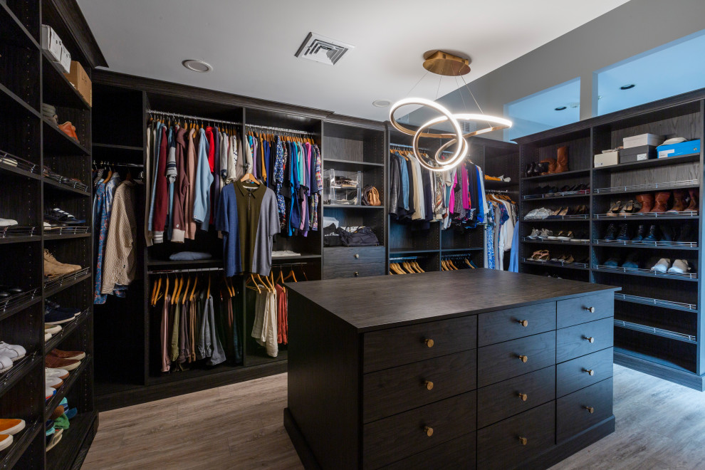 Inspiration for a large contemporary gender-neutral walk-in wardrobe in New York with flat-panel cabinets, dark wood cabinets, laminate floors and multi-coloured floor.