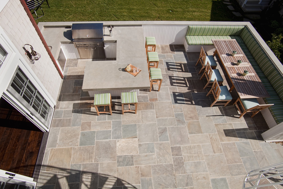 West Coast Hamptons -  The covered patio flooring is finished with bluestone, a stone fireplace with TV, boxed beams and infrared heaters. A spiral staircase leads up to a large upper deck perfect for catching summer sunsets. A black & white tiled mudroom with kid lockers and shoe storage connects the garage with the kitchen. The three car garage is tucked around the side of the home.