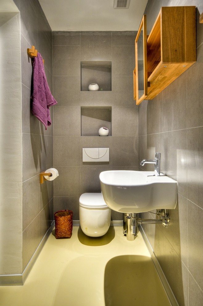 Design ideas for a contemporary bathroom with a wall-mount sink, a wall-mount toilet and yellow floor.