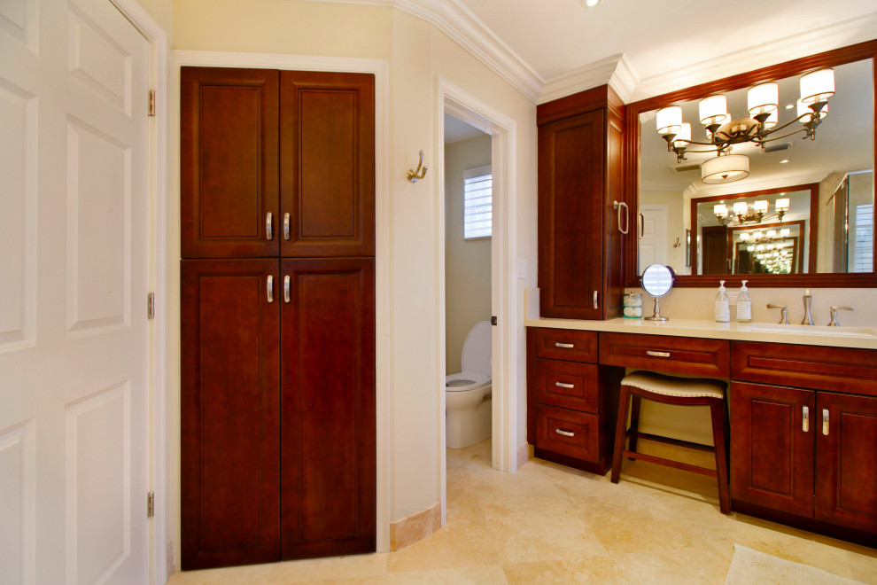 Inredning av ett klassiskt beige beige badrum, med luckor med upphöjd panel, bruna skåp, ett undermonterat badkar, beige kakel, marmorkakel, beige väggar, marmorgolv, ett undermonterad handfat, bänkskiva i kvarts och beiget golv