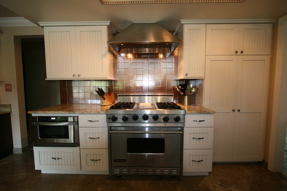 Eat-in kitchen - large transitional l-shaped terra-cotta tile eat-in kitchen idea in Miami with an undermount sink, shaker cabinets, white cabinets, granite countertops, brown backsplash, metal backsplash, stainless steel appliances and an island