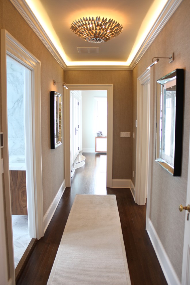 Photo of a mid-sized contemporary hallway in New York with white walls and dark hardwood floors.