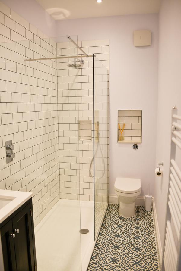 Réalisation d'une petite salle d'eau marine avec un placard à porte shaker, des portes de placard bleues, un plan de toilette en quartz modifié, un plan de toilette blanc, meuble simple vasque et meuble-lavabo sur pied.