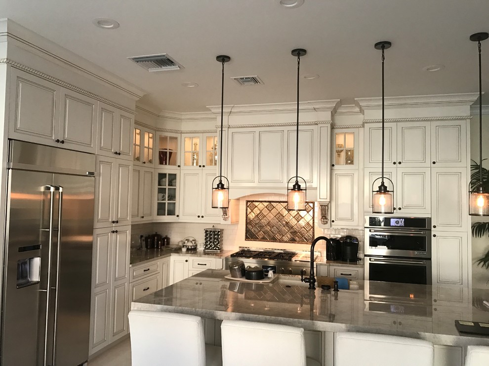 Large minimalist single-wall enclosed kitchen photo with a double-bowl sink, marble backsplash and stainless steel appliances