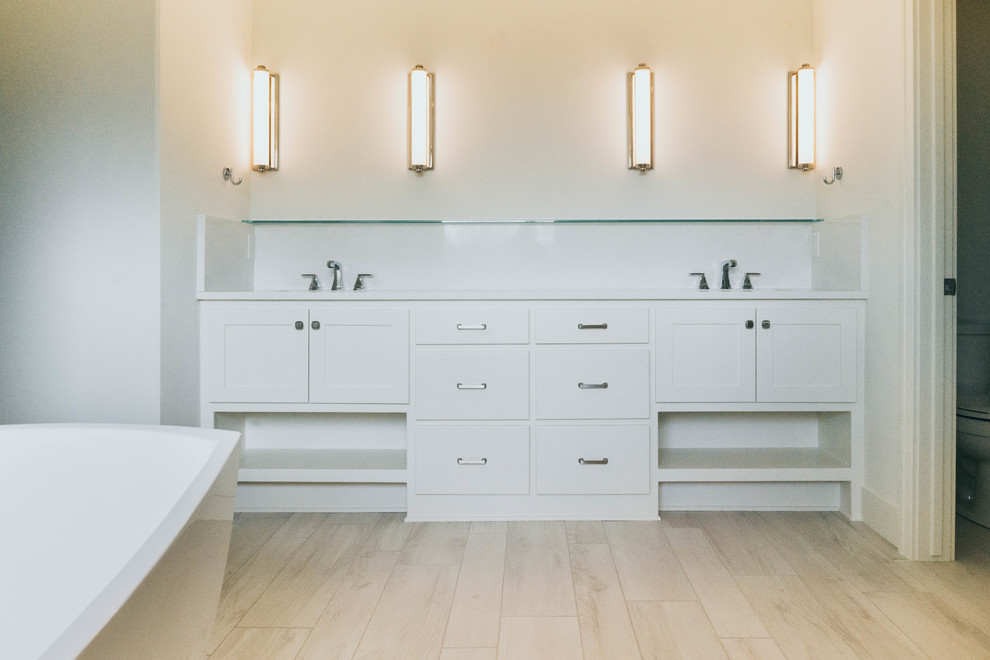 Inspiration for a transitional master white tile porcelain tile freestanding bathtub remodel in Omaha with shaker cabinets, white cabinets, a two-piece toilet, an undermount sink, quartz countertops and white countertops