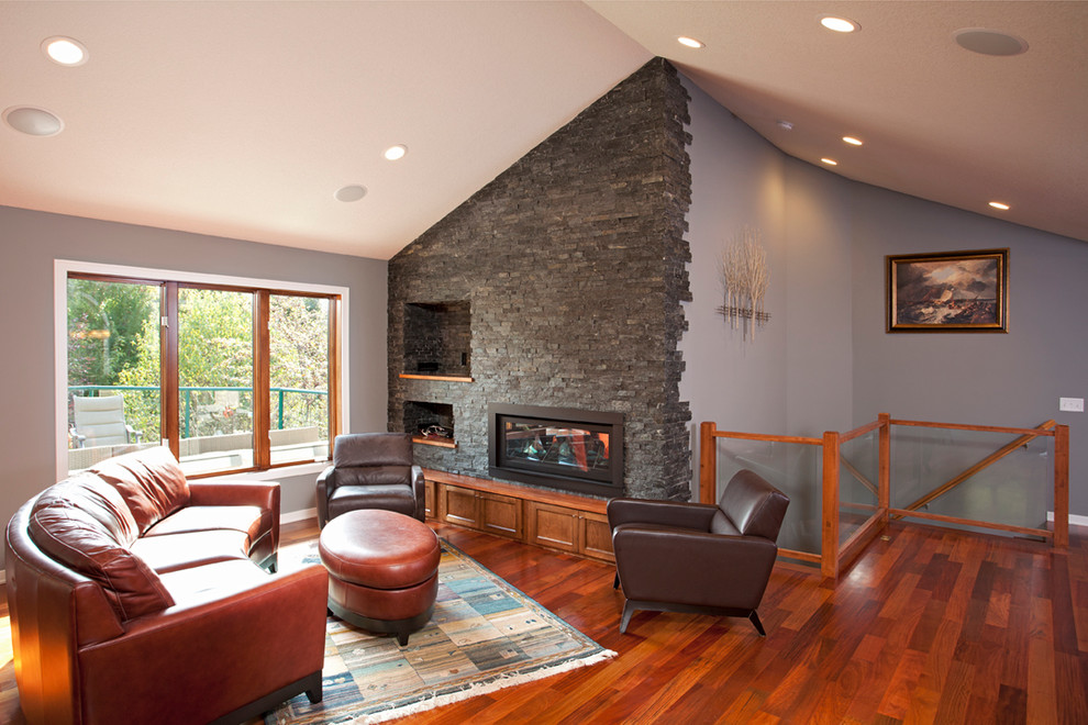 Design ideas for a mid-sized traditional open concept family room in Minneapolis with medium hardwood floors, a standard fireplace, a stone fireplace surround and a built-in media wall.