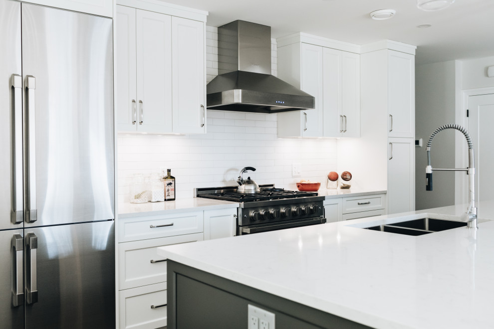 Inspiration for a mid-sized transitional galley kitchen remodel in Vancouver with an undermount sink, shaker cabinets, quartz countertops, white backsplash, subway tile backsplash, stainless steel appliances, an island, white countertops and white cabinets