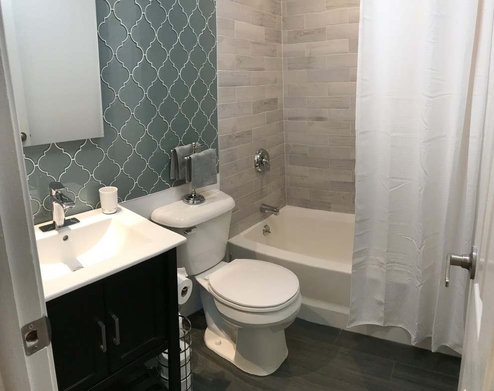 Small transitional master bathroom with a corner tub, a corner shower, a one-piece toilet, blue tile, glass tile, porcelain floors, brown floor and a shower curtain.