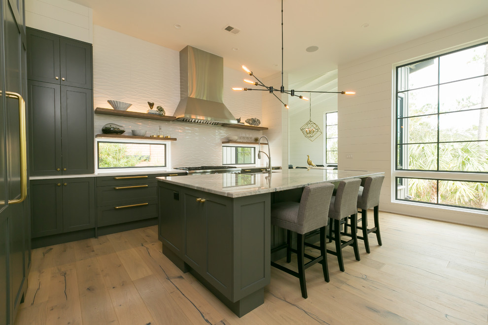 Photo of a mid-sized contemporary l-shaped open plan kitchen in Charleston with an undermount sink, shaker cabinets, grey cabinets, marble benchtops, white splashback, ceramic splashback, stainless steel appliances, medium hardwood floors and with island.