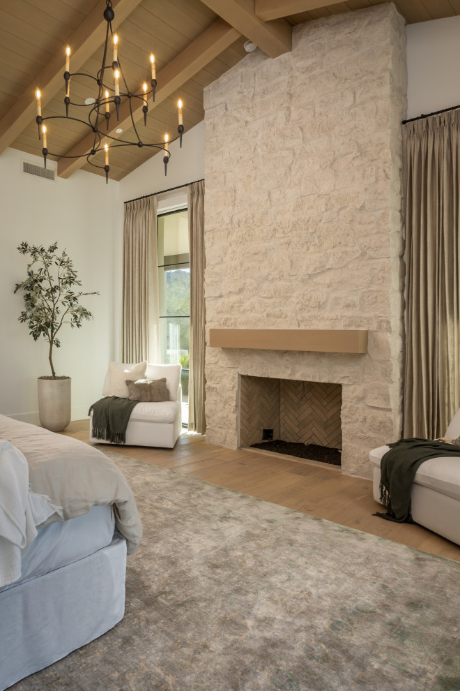 フェニックスにある広いトランジショナルスタイルのおしゃれな主寝室 (白い壁、淡色無垢フローリング、標準型暖炉、石材の暖炉まわり、ベージュの床、板張り天井、板張り壁) のインテリア