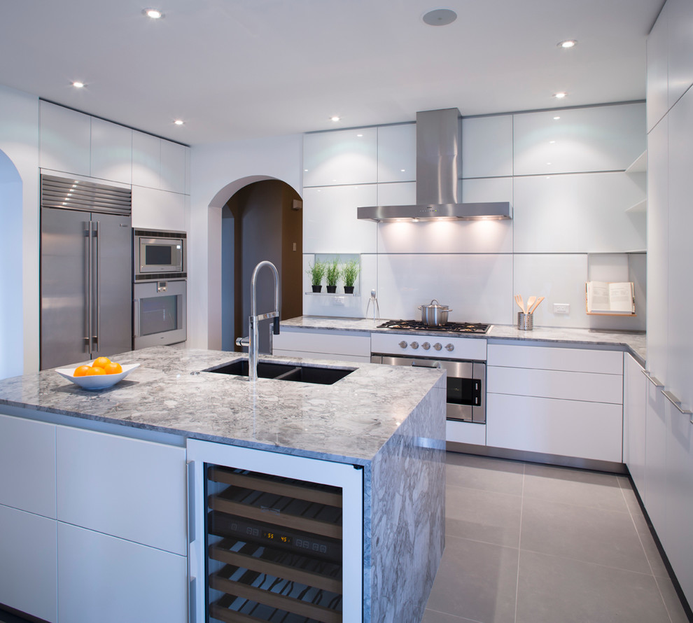Photo of a mid-sized modern u-shaped separate kitchen in Calgary with an undermount sink, flat-panel cabinets, white cabinets, granite benchtops, white splashback, glass sheet splashback, stainless steel appliances, porcelain floors and with island.
