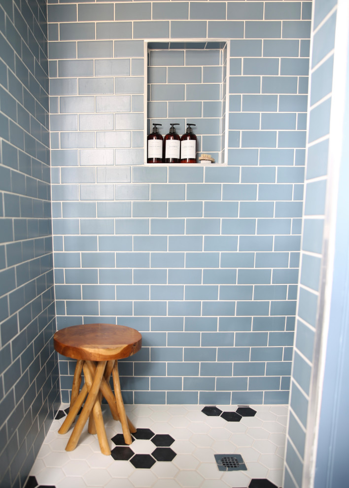 Beach style bathroom in Raleigh with a corner shower, blue walls, ceramic floors, multi-coloured floor and a niche.