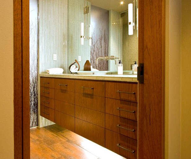 This is an example of a mid-sized modern master bathroom in San Luis Obispo with flat-panel cabinets, medium wood cabinets, beige tile, beige walls, light hardwood floors, a vessel sink and granite benchtops.