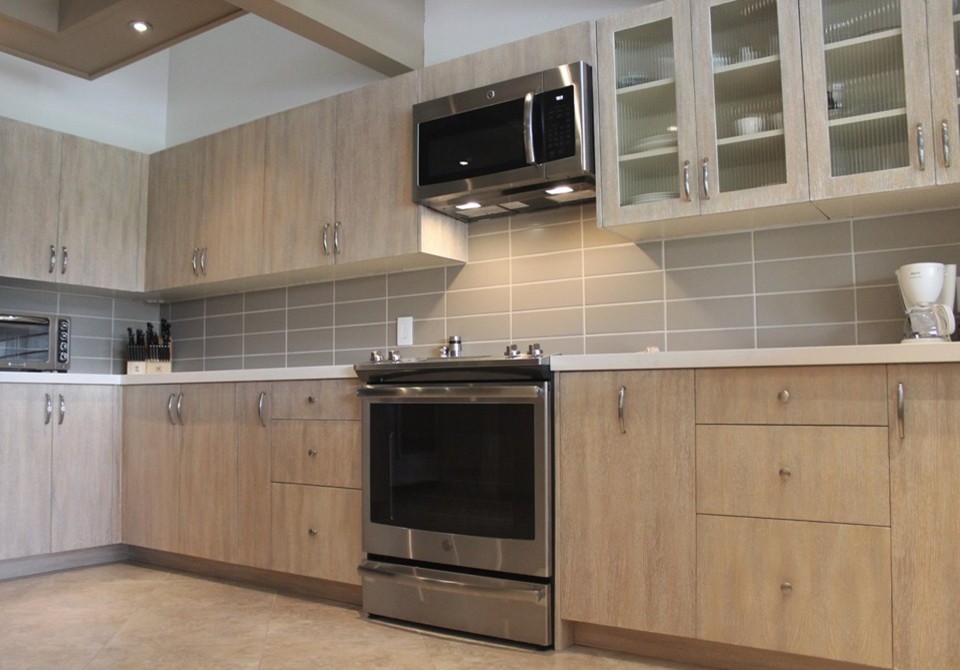 Mid-sized transitional u-shaped porcelain tile and beige floor eat-in kitchen photo with flat-panel cabinets, light wood cabinets, quartz countertops, gray backsplash, ceramic backsplash, stainless steel appliances, no island and beige countertops