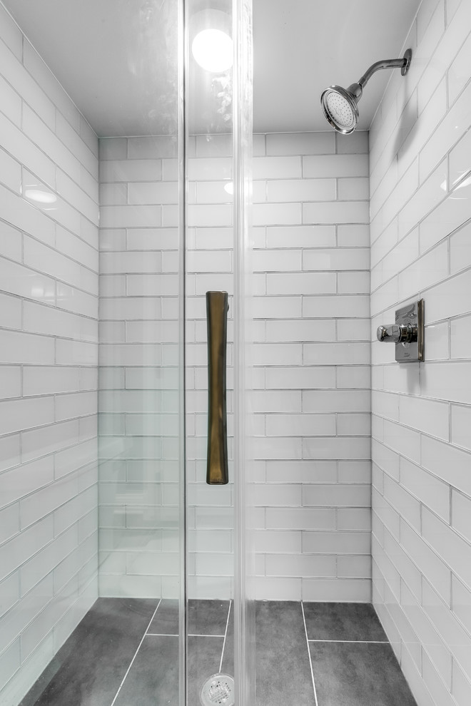Photo of a small transitional 3/4 bathroom in Chicago with flat-panel cabinets, white cabinets, an alcove shower, a two-piece toilet, gray tile, glass tile, beige walls, cement tiles, an integrated sink, solid surface benchtops, grey floor and a sliding shower screen.