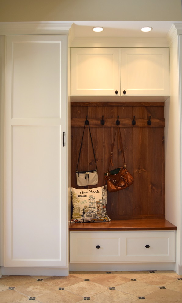 Example of a mid-sized transitional ceramic tile mudroom design in New York with beige walls and a white front door