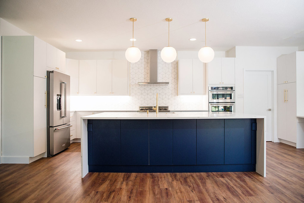 Example of a large transitional u-shaped vinyl floor and brown floor eat-in kitchen design in Austin with an undermount sink, flat-panel cabinets, white cabinets, quartz countertops, white backsplash, stainless steel appliances, an island and white countertops
