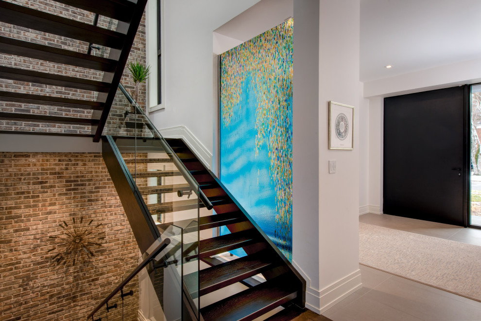 トロントにある高級な広いコンテンポラリースタイルのおしゃれな階段 (ガラスフェンス、レンガ壁) の写真