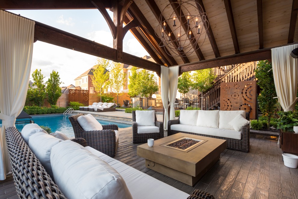 This is an example of a transitional backyard deck in Toronto with a fire feature.