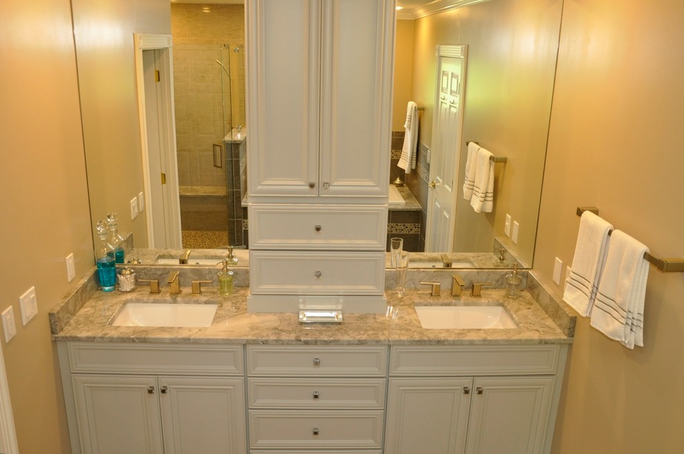 Photo of a mid-sized transitional master bathroom in Cincinnati with an undermount sink, recessed-panel cabinets, grey cabinets, granite benchtops, a drop-in tub, a corner shower, gray tile, porcelain tile, grey walls and porcelain floors.