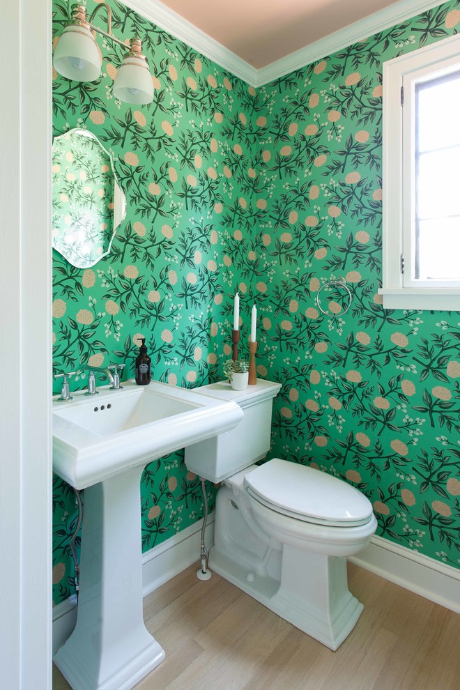 Design ideas for a small traditional powder room in Minneapolis with a two-piece toilet, green walls, light hardwood floors, a pedestal sink and beige floor.