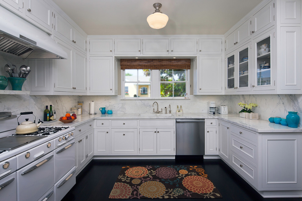Traditional separate kitchen in Los Angeles with glass-front cabinets, white appliances, white cabinets, white splashback and marble splashback.
