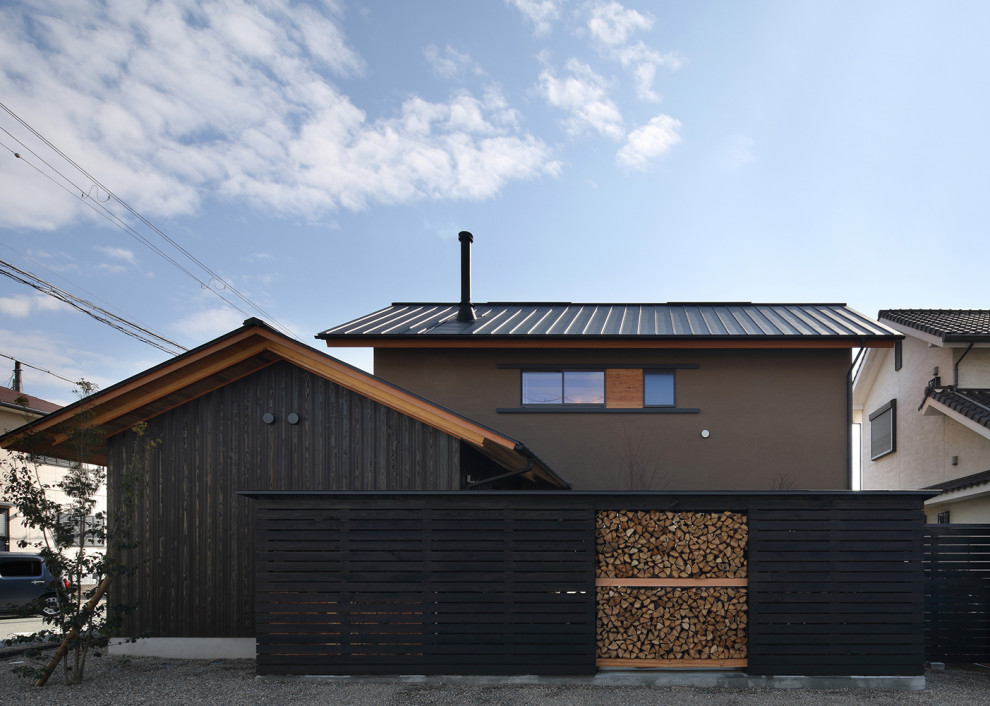 Пример оригинального дизайна: большой, двухэтажный, деревянный, коричневый частный загородный дом в восточном стиле с двускатной крышей, металлической крышей, черной крышей и отделкой доской с нащельником