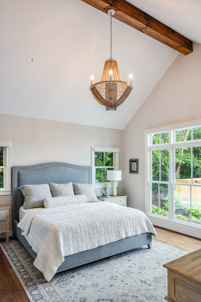 Inspiration for a transitional master medium tone wood floor, brown floor and exposed beam bedroom remodel with beige walls