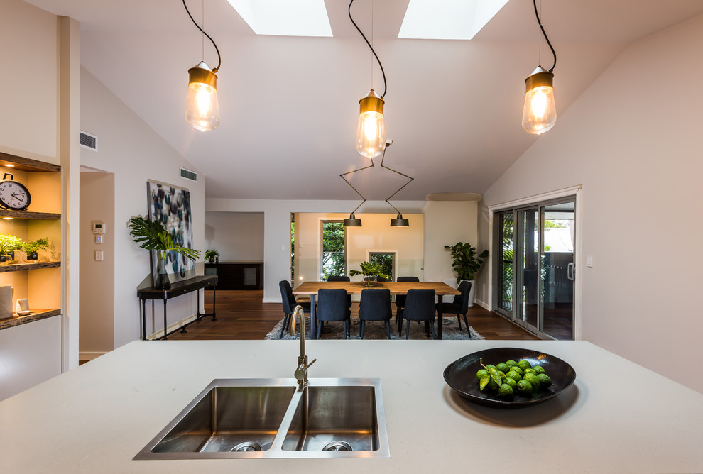 Inspiration for a large contemporary galley eat-in kitchen in Sydney with a triple-bowl sink, flat-panel cabinets, beige cabinets, quartz benchtops, white splashback, subway tile splashback, stainless steel appliances, medium hardwood floors, with island and orange floor.
