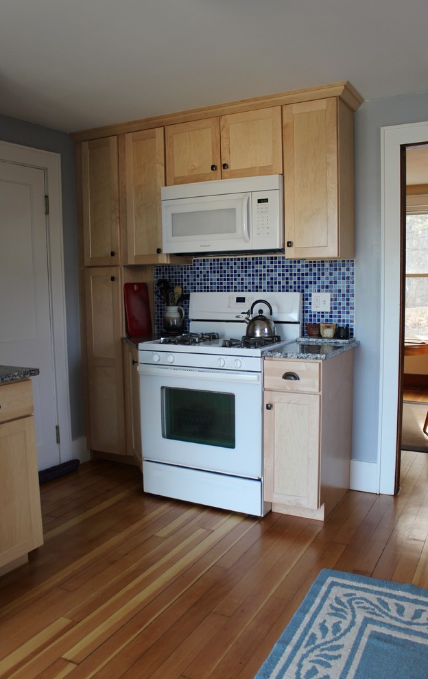 Inspiration for a small arts and crafts u-shaped eat-in kitchen in Portland Maine with a single-bowl sink, shaker cabinets, light wood cabinets, granite benchtops, blue splashback, mosaic tile splashback, white appliances, medium hardwood floors and no island.