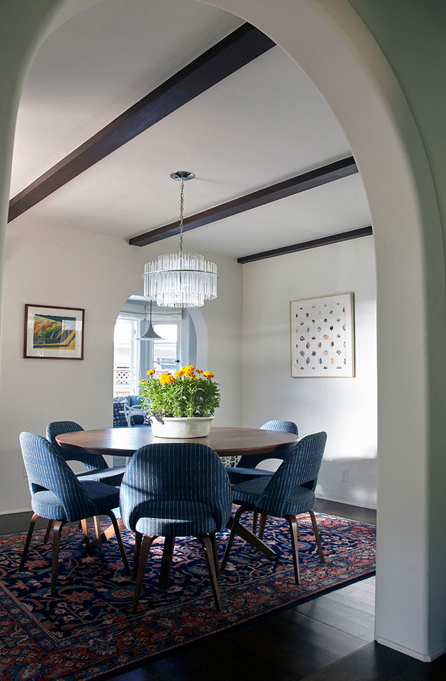This is an example of a transitional separate dining room in Los Angeles with white walls, dark hardwood floors, no fireplace and black floor.