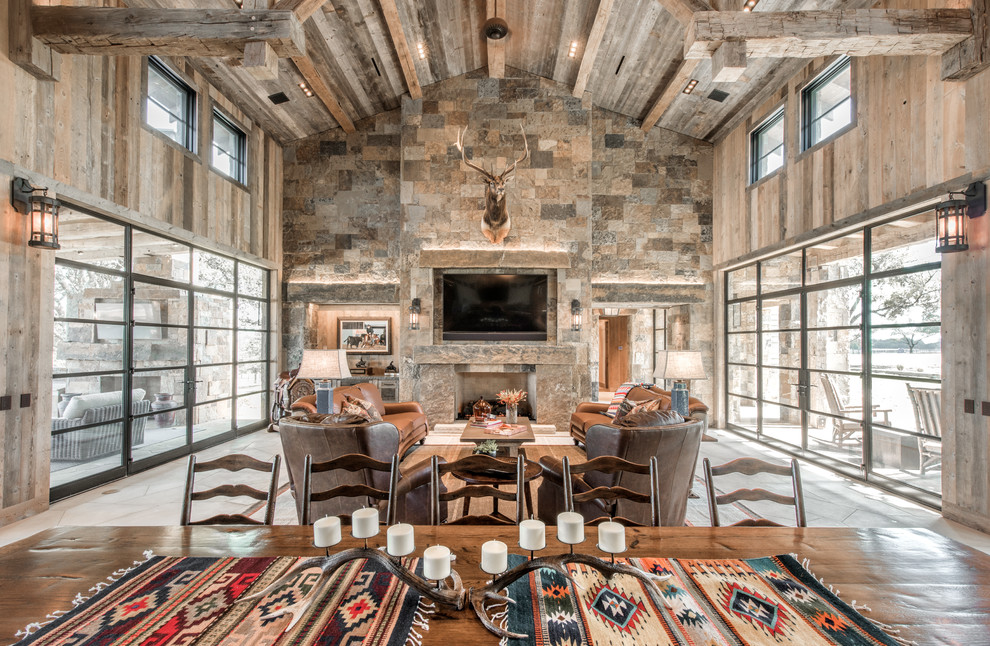 Country open concept living room in Dallas with a standard fireplace, a stone fireplace surround and a wall-mounted tv.