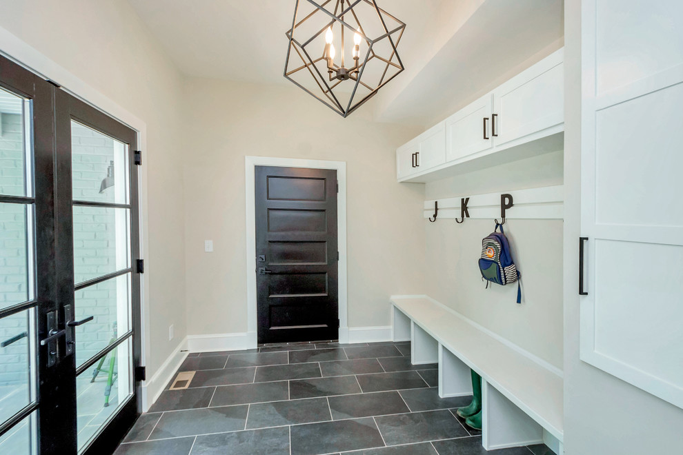 This is an example of a mid-sized industrial mudroom in DC Metro with beige walls, slate floors, a double front door, a glass front door and grey floor.