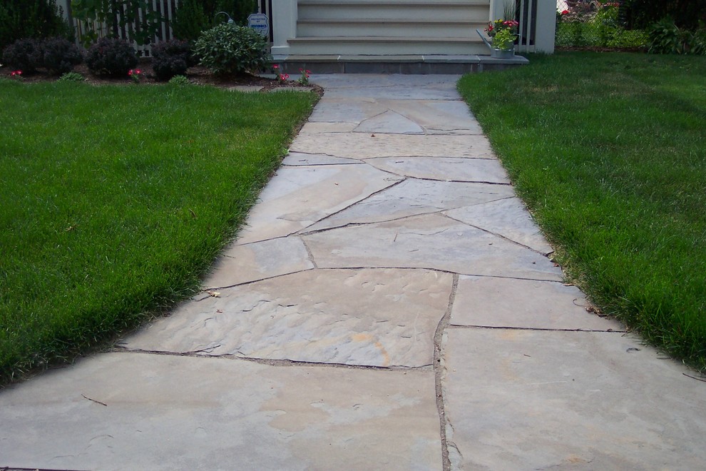 This is an example of a mid-sized transitional front yard full sun garden for summer in Chicago with natural stone pavers.