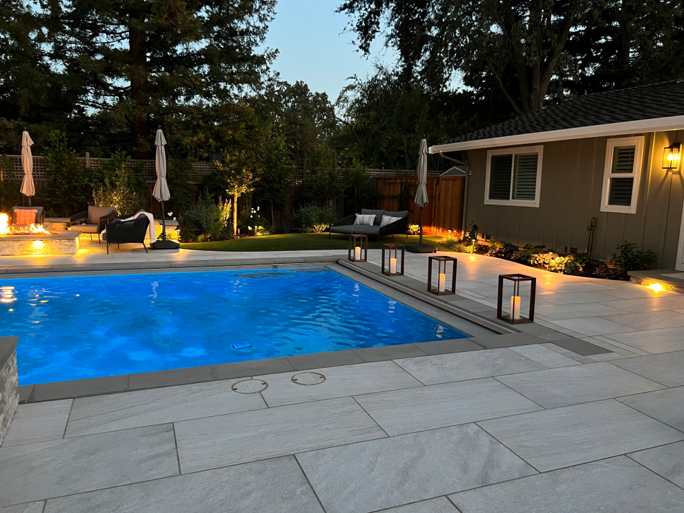 Esempio di una grande piscina american style rettangolare dietro casa con paesaggistica bordo piscina e piastrelle