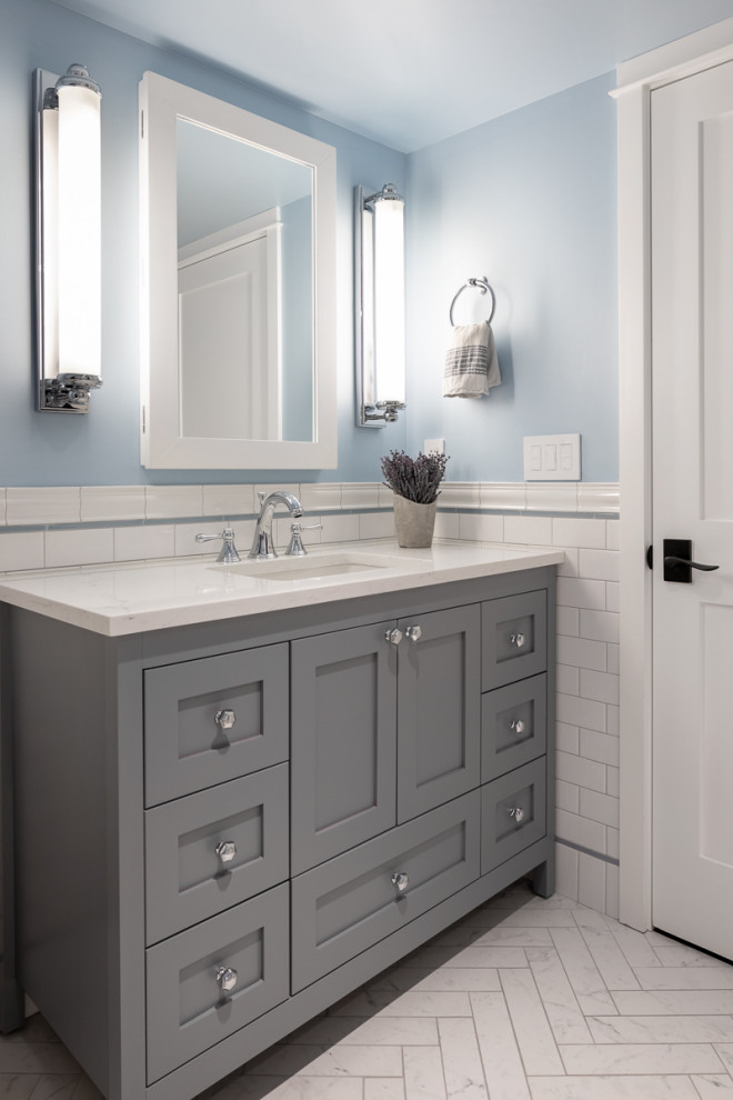 This is an example of a small transitional kids bathroom in Seattle with furniture-like cabinets, grey cabinets, an alcove tub, an alcove shower, a one-piece toilet, white tile, porcelain tile, blue walls, porcelain floors, an undermount sink, engineered quartz benchtops, multi-coloured floor, a shower curtain, white benchtops, a niche, a single vanity, a freestanding vanity and decorative wall panelling.