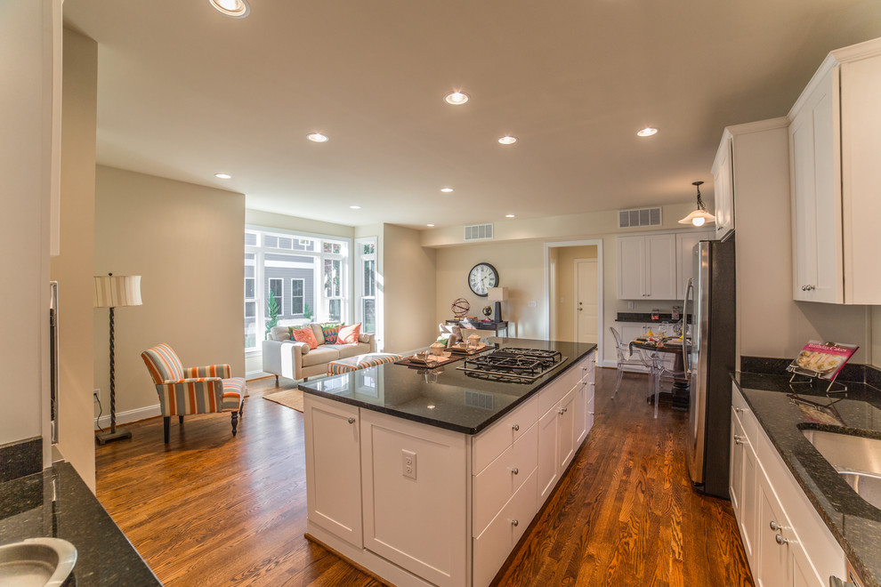 Example of a transitional l-shaped dark wood floor open concept kitchen design in DC Metro with an undermount sink, recessed-panel cabinets, white cabinets, granite countertops, stainless steel appliances and an island