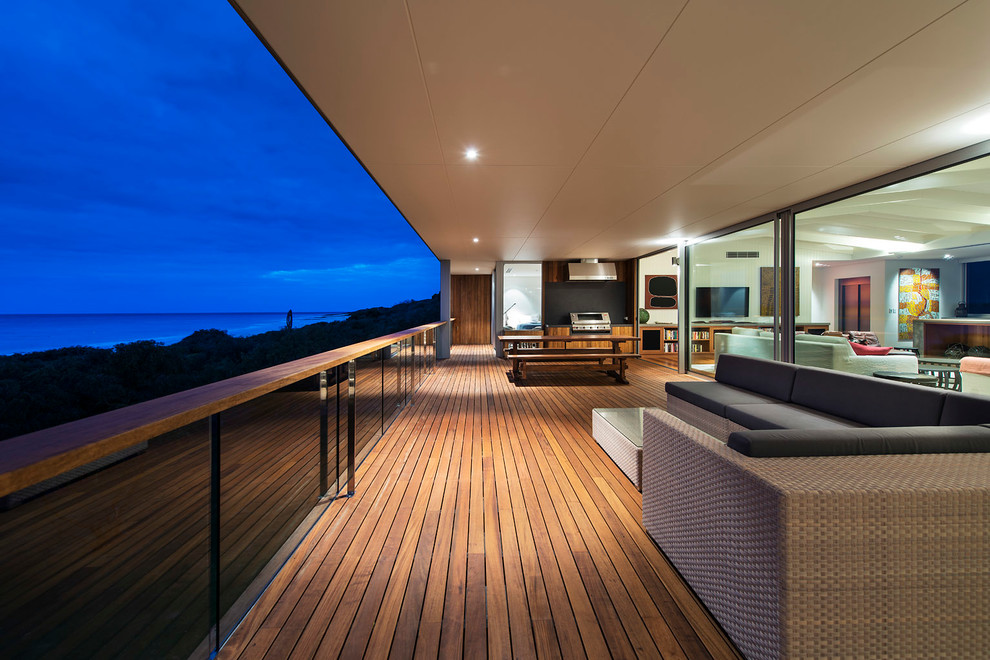 This is an example of a contemporary backyard deck in Perth with a roof extension and an outdoor kitchen.
