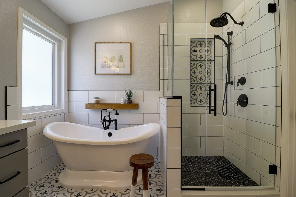 Medium sized rural ensuite bathroom in Phoenix with shaker cabinets, grey cabinets, a freestanding bath, a corner shower, a two-piece toilet, black and white tiles, porcelain tiles, grey walls, porcelain flooring, a submerged sink, engineered stone worktops, multi-coloured floors, a hinged door, white worktops, a wall niche, double sinks and a vaulted ceiling.