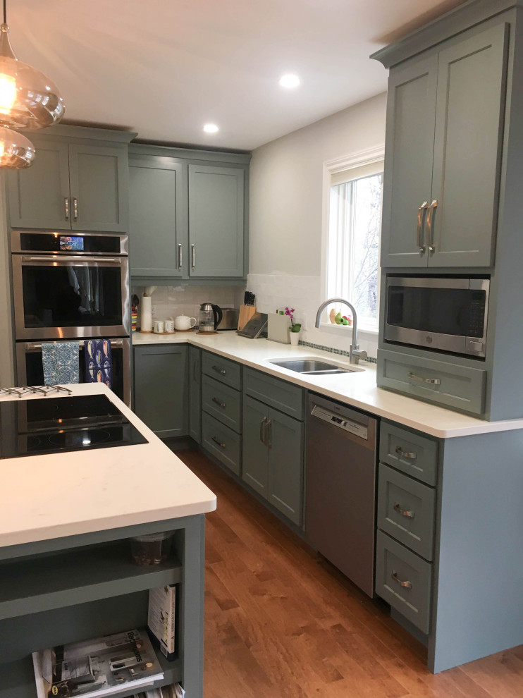 Inspiration for a mid-sized transitional l-shaped medium tone wood floor and brown floor enclosed kitchen remodel with a double-bowl sink, shaker cabinets, gray cabinets, quartz countertops, white backsplash, porcelain backsplash, stainless steel appliances, an island and white countertops