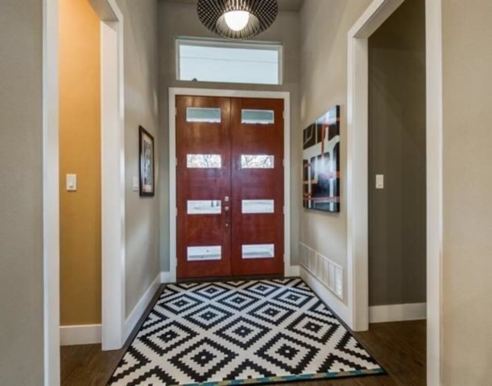This is an example of a mid-sized contemporary foyer in Dallas with beige walls, dark hardwood floors, a double front door and a dark wood front door.