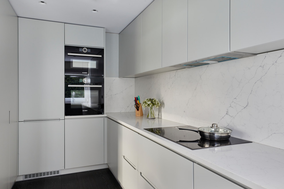 Mid-sized modern u-shaped separate kitchen in London with an undermount sink, recessed-panel cabinets, grey cabinets, marble benchtops, grey splashback, marble splashback, panelled appliances, dark hardwood floors, no island, black floor and grey benchtop.