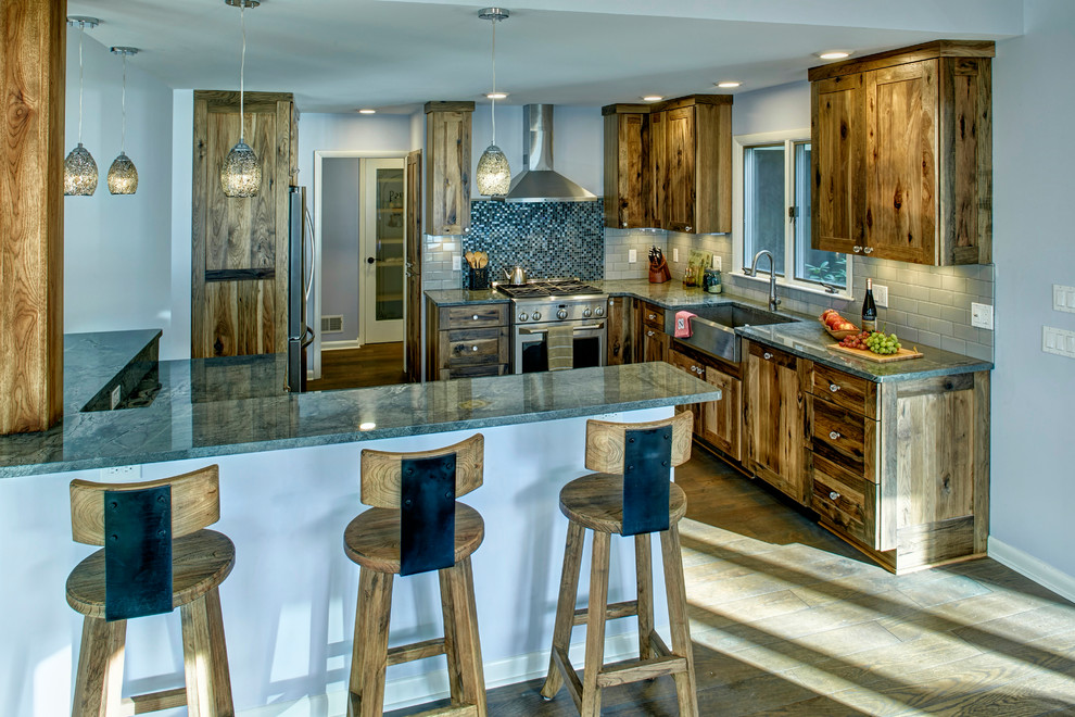 Inspiration for a mid-sized rustic light wood floor kitchen remodel with a farmhouse sink, recessed-panel cabinets, granite countertops, glass tile backsplash, stainless steel appliances and an island
