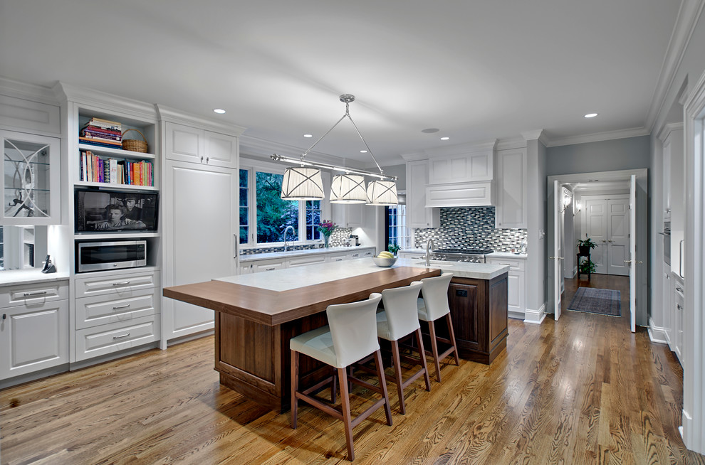 Large transitional u-shaped medium tone wood floor and brown floor eat-in kitchen photo in Chicago with raised-panel cabinets, white cabinets, quartzite countertops, multicolored backsplash, mosaic tile backsplash, an island and white countertops