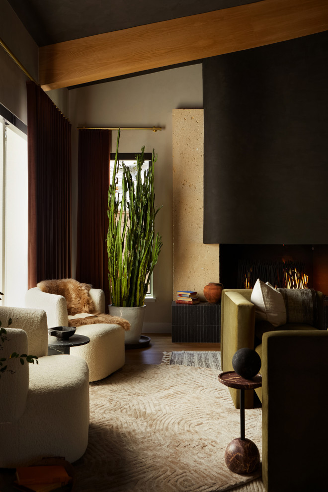 ダラスにある高級な中くらいなコンテンポラリースタイルのおしゃれなリビング (ベージュの壁、無垢フローリング、標準型暖炉、コンクリートの暖炉まわり、茶色い床、表し梁) の写真