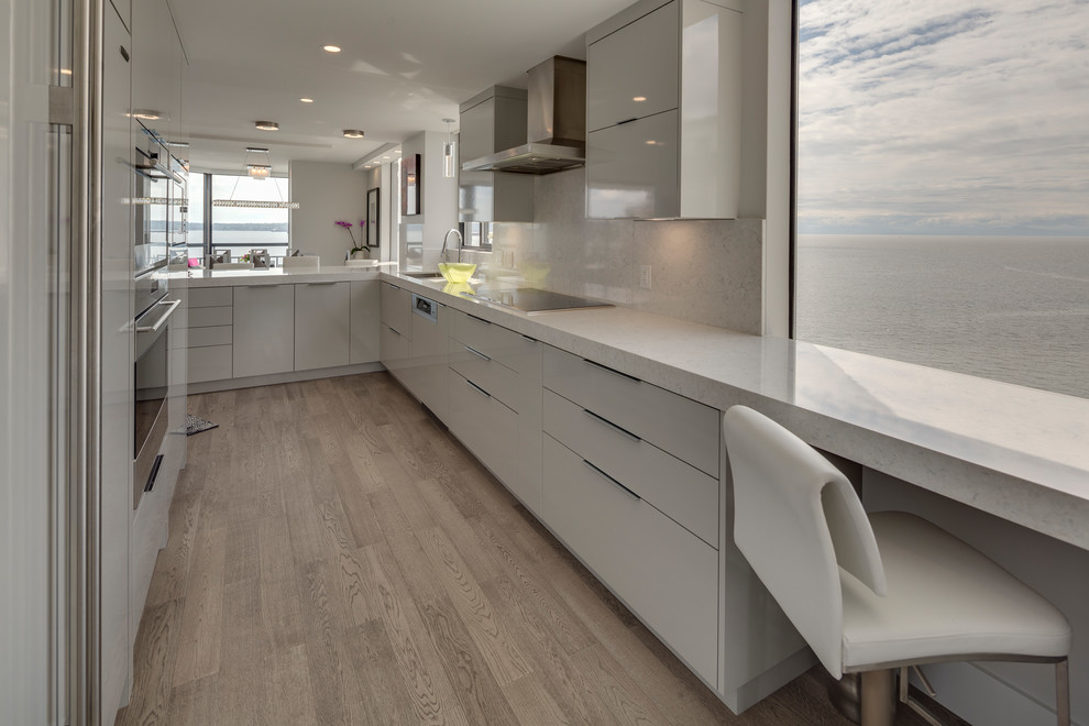 Inspiration for a mid-sized kitchen in Vancouver with flat-panel cabinets, grey cabinets, quartz benchtops, grey splashback, stainless steel appliances and with island.