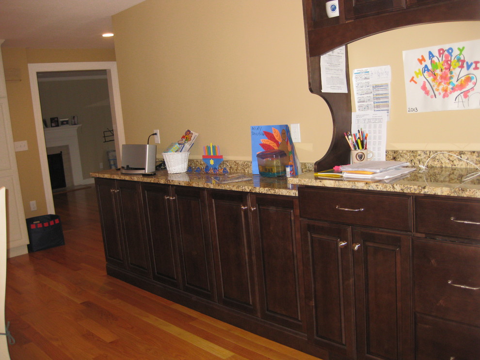Transitional l-shaped light wood floor eat-in kitchen photo in Boston with beige walls, an undermount sink, raised-panel cabinets, white cabinets, granite countertops, beige backsplash, ceramic backsplash, stainless steel appliances and an island