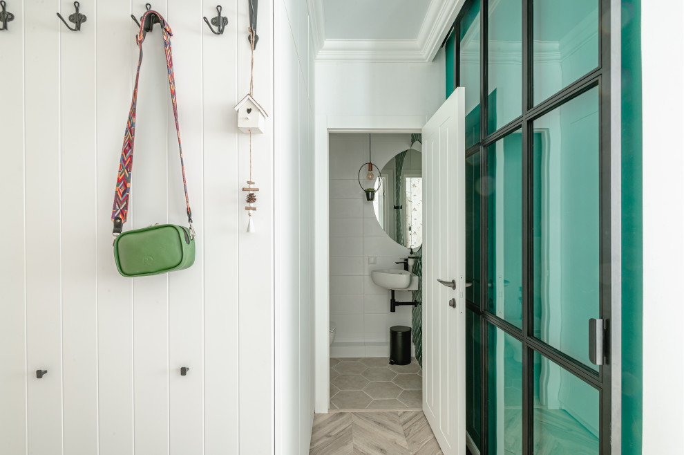 На фото: маленькая входная дверь в скандинавском стиле с белыми стенами, полом из керамогранита, одностворчатой входной дверью, коричневой входной дверью и бежевым полом для на участке и в саду с