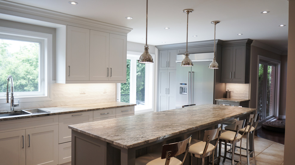 Kitchen - large transitional u-shaped kitchen idea in Toronto with a single-bowl sink, shaker cabinets, white cabinets, granite countertops, white backsplash, porcelain backsplash, stainless steel appliances and an island