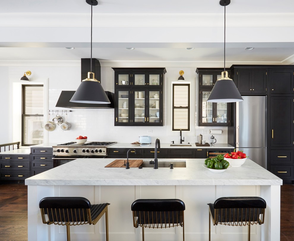 Inspiration for a transitional kitchen in Chicago with an undermount sink, glass-front cabinets, black cabinets, white splashback, stainless steel appliances, dark hardwood floors, with island and brown floor.